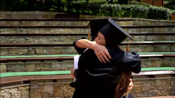 庆祝和拥抱刚毕业的学生的快乐夫妇