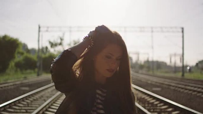 走在铁路上的年轻女子。摇滚风格。