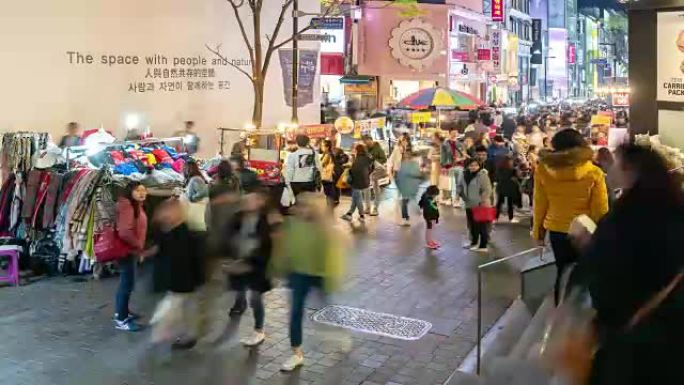 延时: 夜间在韩国首尔明洞市中心购物街的行人