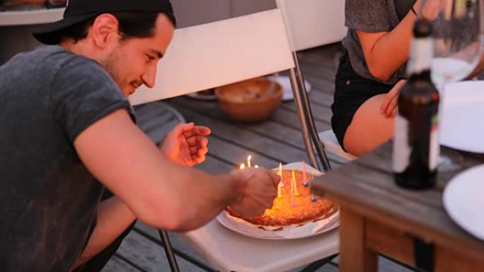 年轻人用打火机点燃蛋糕上的蜡烛