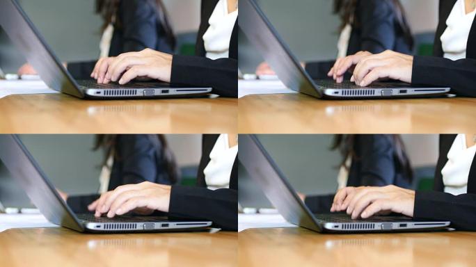 女商人在笔记本电脑键盘上打字的特写，用于会议室的会议记录
