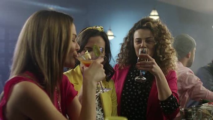 三个女性朋友在鸡尾酒吧喝酒闲聊