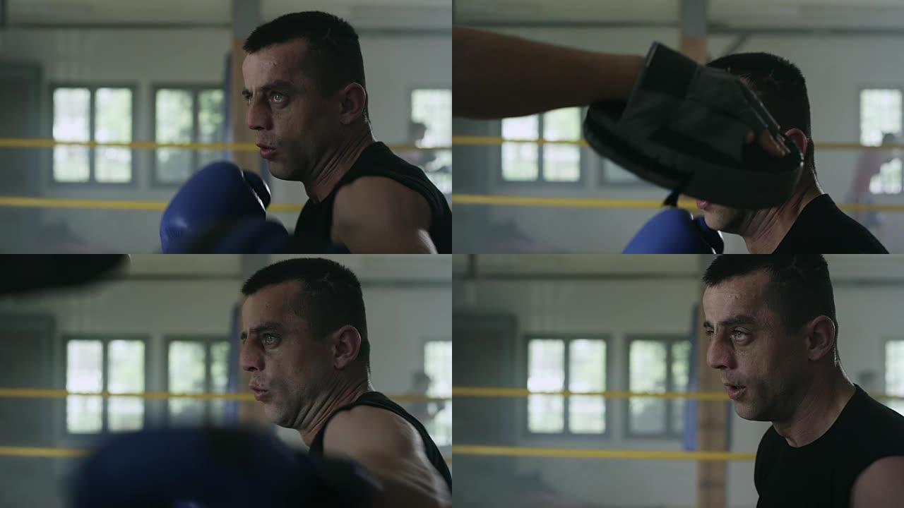 男拳击手在健身房与教练一起练习