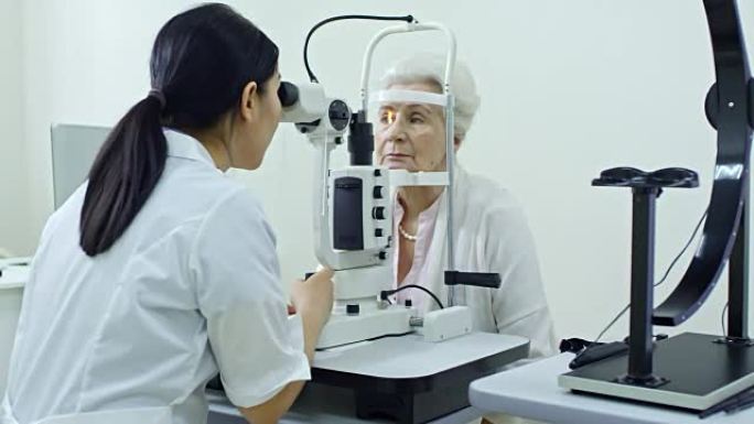 女性验光师对高级女性进行眼科检查