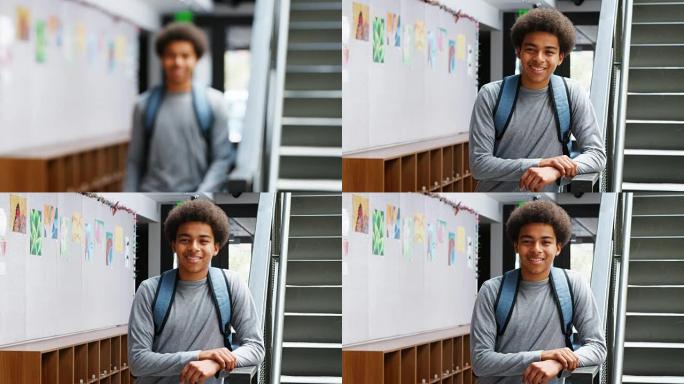 男高中生站在大学大楼楼梯旁的肖像