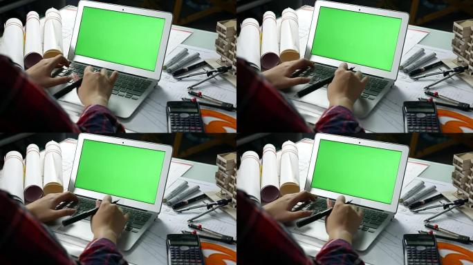 设计师使用带绿屏的笔记本电脑，
