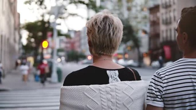 慢动作两个快乐的年轻朋友一起散步，聊天，微笑和探索纽约市的晚间街道