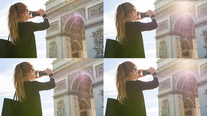 年轻的女游客走在巴黎的街道上并拍摄凯旋门的照片