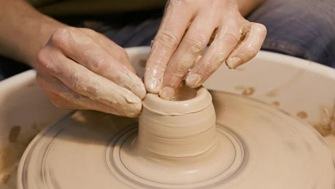 男人用陶工的轮子工作，只有手