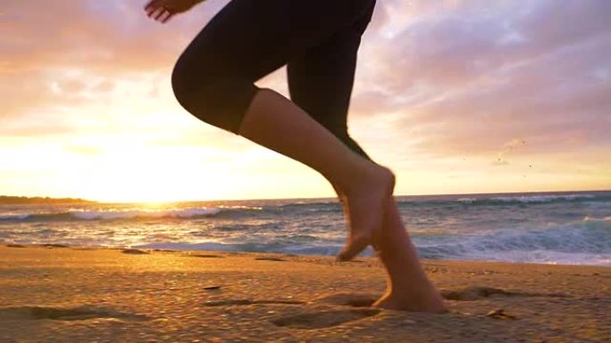 慢动作: 未知的女人，运动腿在阳光明媚的海岸上的湿沙中慢跑