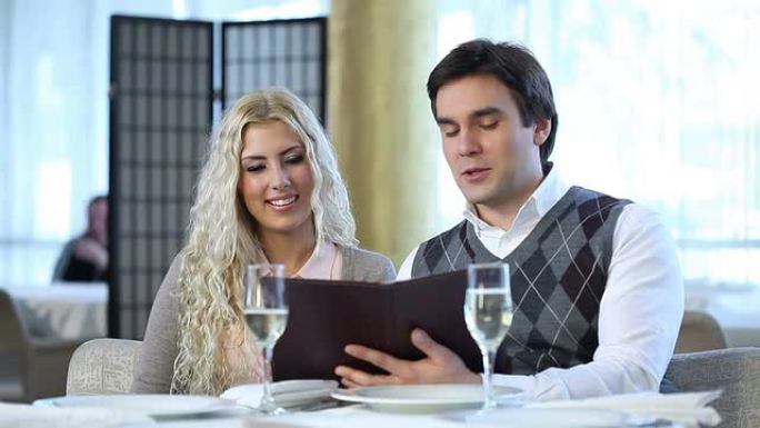 年轻夫妇在餐厅阅读菜单