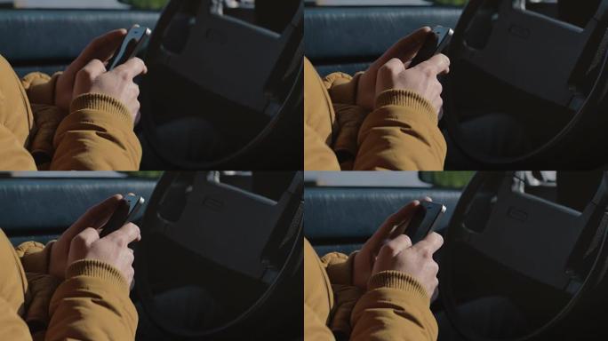 男人在车里用手机发短信。
