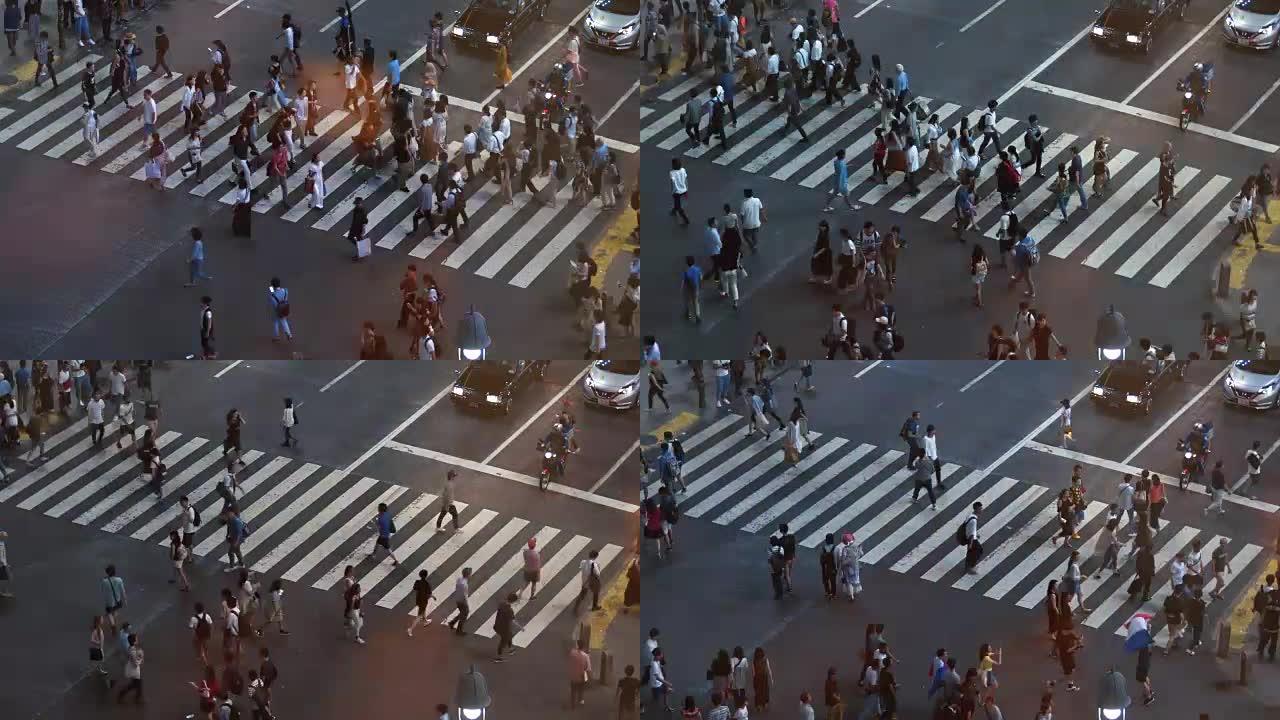 人们在人行横道上行走的高角度延时拍摄。晚上人行横道上挤满了人的大城市。