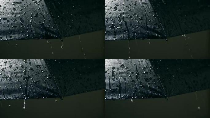雨落在伞上，特写夜晚的雨滴雨水特写