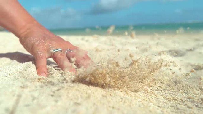 慢动作: 无法辨认的女人用手指穿过滚烫的白沙。