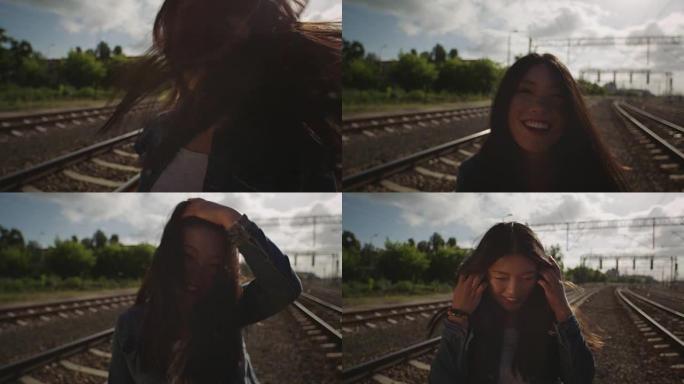 亚洲年轻女子在铁路上乱扔头发。
