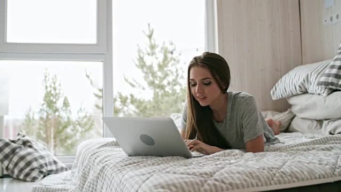 女人在卧室里使用笔记本电脑