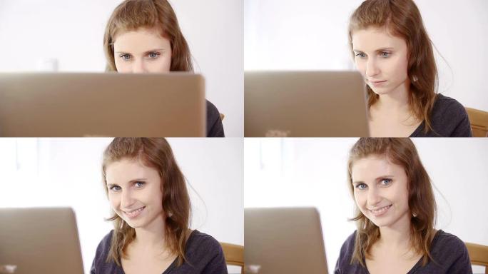 笔记本电脑屏幕后面的年轻女人