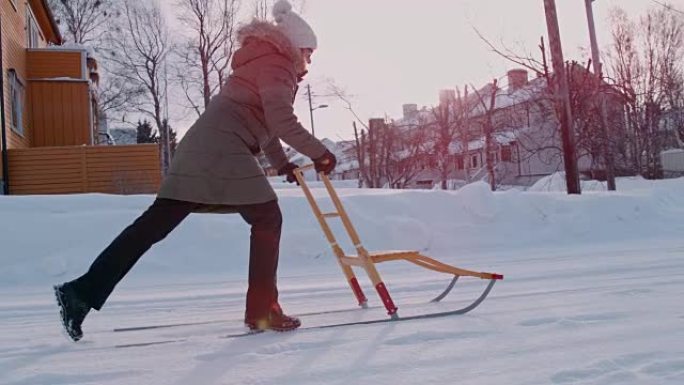 SLO MO女人在雪地里用踢腿雪橇