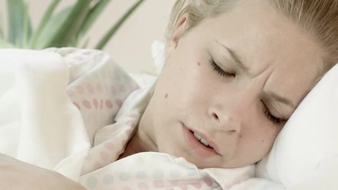 生病的女人躺在床上吹鼻子