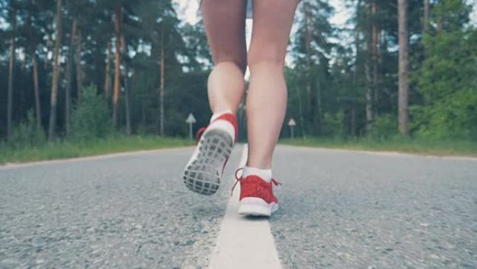 女性脚踝开始慢动作跑步的特写。女运动员慢跑。