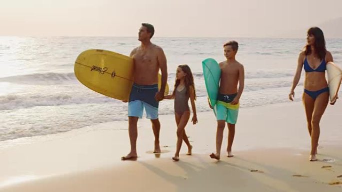 年轻的家庭去冲浪一家人去游泳。旅行