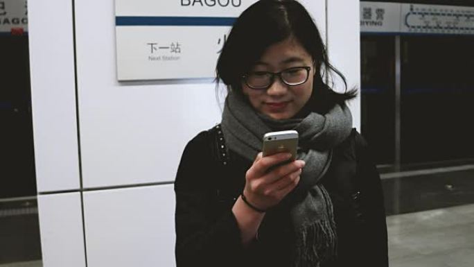 亚洲女孩在地铁站使用手机/中国北京