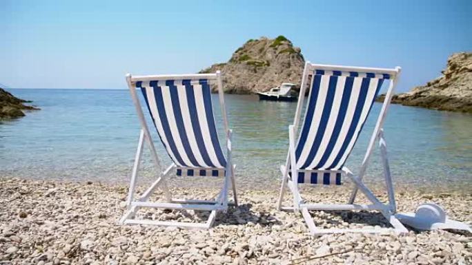 田园诗般的海滩上的两把空太阳椅
