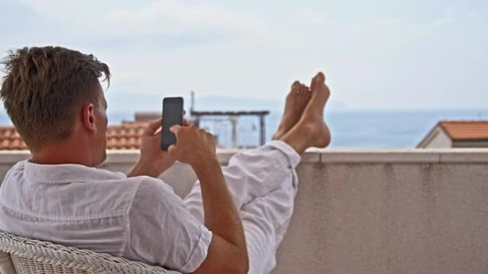 DS男子在阳台上使用智能手机