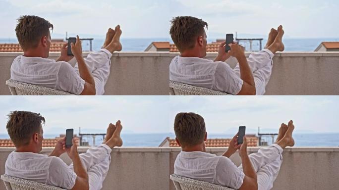 DS男子在阳台上使用智能手机