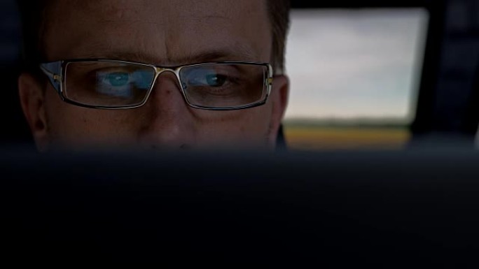 戴眼镜的人在电脑上工作