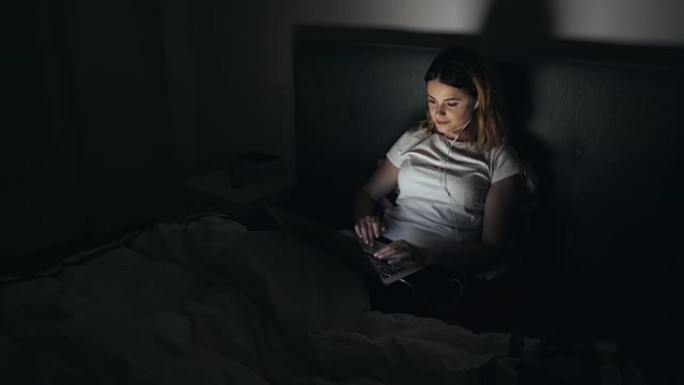 年轻女子深夜使用笔记本电脑。