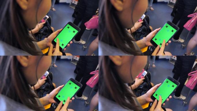 亚洲妇女在火车上使用带有绿屏的智能手机，慢动作