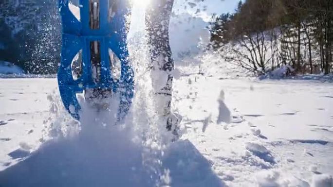 女人雪鞋在新鲜的雪上行走