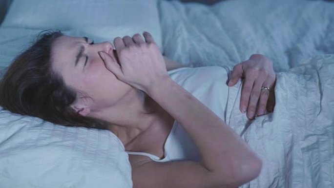 躺在床上的女人感到恶心，并有感冒，发热和胃痛的症状。概念: 疫苗、疾病、药物