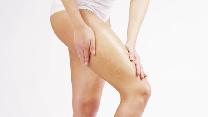 女人在腿上涂抹奶油