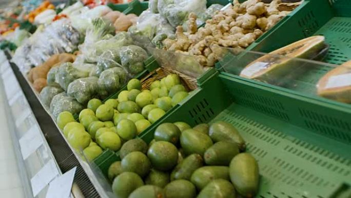 在超市: 商店新鲜农产品区的滑行镜头。农贸市场上出售的异国水果和有机蔬菜。