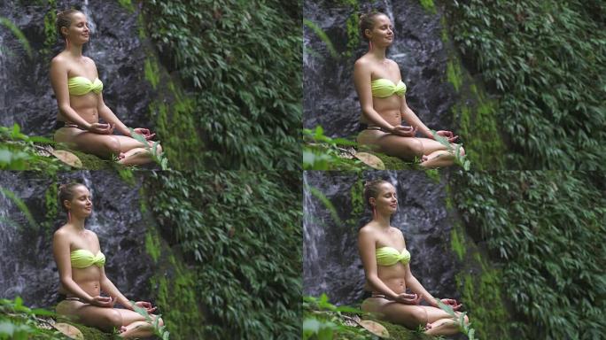 在瀑布旁沉思的女人。热带雨林。假日放松