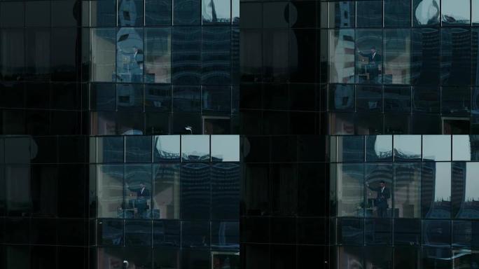 鸟瞰图: 从外面进入办公楼，商人使用手机，站在办公室窗户旁边。美丽的飞拍金融商务区摩天大楼。