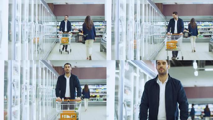 在超市: 帅哥推购物卡，在冷冻商品区浏览商品。男人看着玻璃门冰箱，选择乳制品。其他顾客购物。