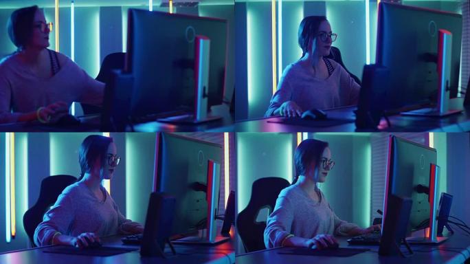美丽的职业玩家女孩坐下来在她的个人电脑上玩第一人称射击在线视频游戏。休闲可爱的怪胎戴着眼镜，对着耳机