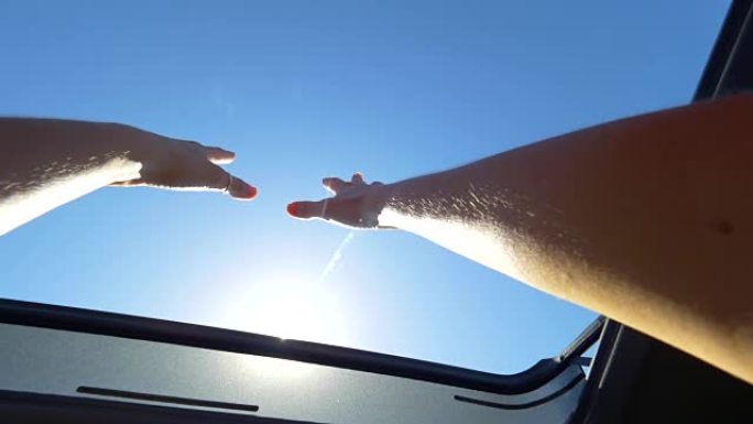 POV: 开朗的女人，带环的手臂伸出汽车的天窗
