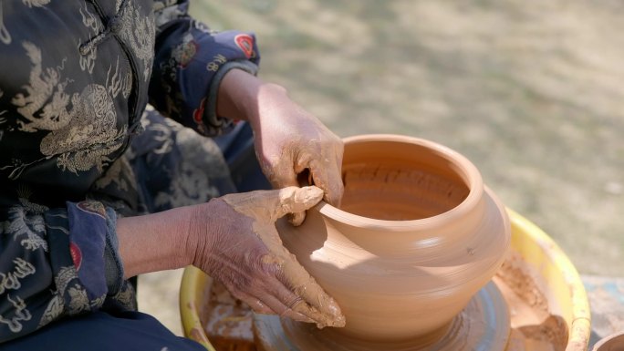 老年和青年制陶匠人制作陶器过程