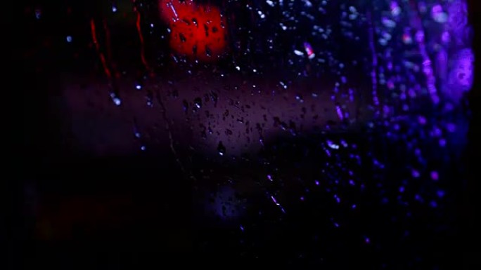 夜间多雨的城市，从行驶中的汽车中模糊的视图