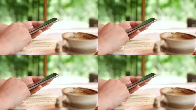 在咖啡户外咖啡馆使用智能手机的女性特写，生活方式