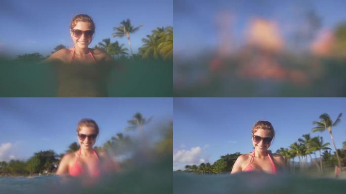 女人在海洋中放松并溅入相机