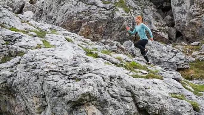 年轻健康的运动女子从陡峭的落基山上坡的人迹罕至的道路上奔跑