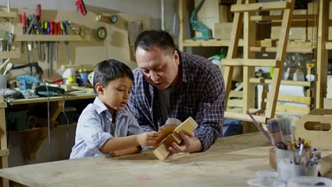 父亲教儿子如何使用砂纸