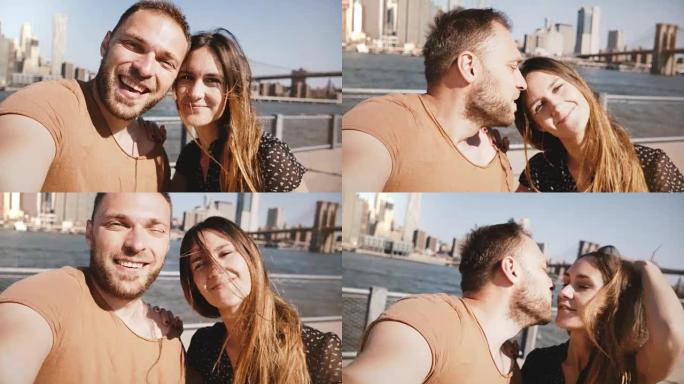 微笑着快乐的高加索年轻夫妇站在史诗般的纽约天际线曼哈顿景色，亲吻并自拍