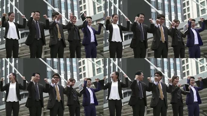 一群快乐的商人表现出成功的迹象。成功的商业团队竖起大拇指。